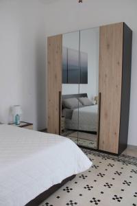 una camera con un letto e un grande specchio di b&b Brupier a Ruvo di Puglia