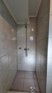 a shower stall in a bathroom with a tile floor at Robinson Alojamientos - Edificio Erico Orlando in Ushuaia +59 photos