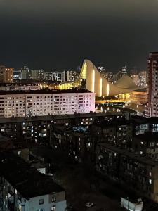 a view of a city at night with a building at Kvartira in Baku