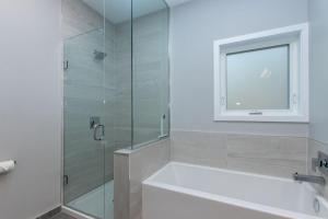 a bathroom with a shower and a tub and a window at 107 Birchview Trail in Blue Mountains