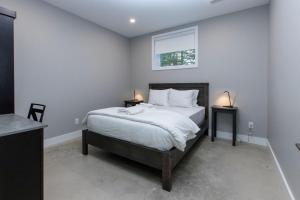 a bedroom with a bed with white sheets and a window at 107 Birchview Trail in Blue Mountains