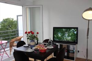 un soggiorno con tavolo e TV di Beau apartment Châtenay-Malabry a Châtenay-Malabry