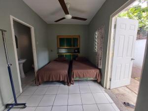 - une chambre avec un lit et un ventilateur de plafond dans l'établissement Labrish Guest House, à Kingston