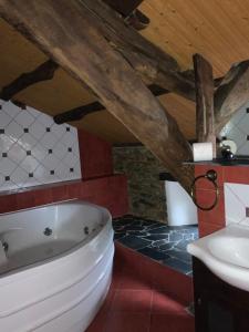 a bathroom with a white tub and a sink at Hotel y Apartamentos Penarronda Playa in Castropol