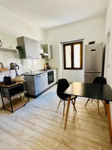 una cucina con tavolo e sedie di SASSARI-CENTRO Elegante Appartamento con WiFi e Netflix a Sassari