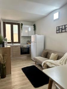 sala de estar con sofá y nevera blanca en SASSARI-CENTRO Elegante Appartamento con WiFi e Netflix, en Sassari