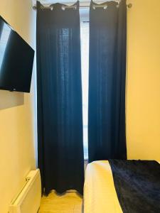 um quarto com uma janela com cortinas azuis em Studio MER gare part dieu em Lyon