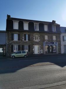 a car parked in front of a brick building at La Monaco du Nord in Granville