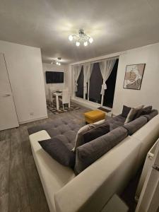 um grande sofá numa sala de estar com televisão em Stunning 1-Bed Apartment in London em Londres