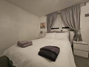 um quarto com uma cama branca com duas toalhas em Stunning 1-Bed Apartment in London em Londres