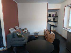 ein Wohnzimmer mit einem Sofa und einem Tisch in der Unterkunft Marguerite in Bussang