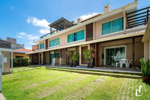 a house with a lawn in front of it at Residencial Maresias - 02 dormitórios in Bombinhas