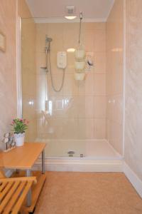 a bathroom with a tub and a table and a bench at Heronlea Cottage in Dunoon +24 photos