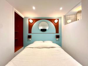 a small bedroom with a bed and a mirror at La Loge Parisienne, 300m gare, Climatisation, Téléphérique in Grenoble +14 photos