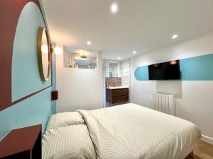 1 dormitorio con 1 cama y TV en la pared en La loge parisienne 300m gare Bastille Téléphérique, en Grenoble