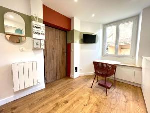 a room with a table and a chair and a window at La Loge Parisienne, 300m gare, Climatisation, Téléphérique in Grenoble