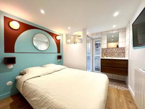 a bedroom with a large bed and a mirror at La Loge Parisienne, 300m gare, Climatisation, Téléphérique in Grenoble