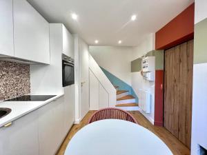 a kitchen with white cabinets and a staircase at La Loge Parisienne, 300m gare, Climatisation, Téléphérique in Grenoble