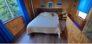 1 dormitorio pequeño con 1 cama y 2 ventanas en Cabaña 3 personas Villarrica Pucón, en Pucón