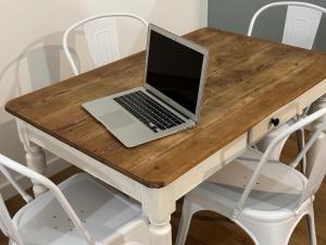 a laptop computer sitting on top of a wooden table at Reyloft • Situé au cœur de Douai & Wifi fibre in Douai