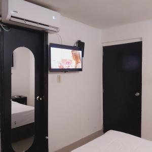 a bedroom with a flat screen tv on the wall at HOTEL SARACHUY VALLEDUPAR in Valledupar
