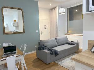 a living room with a couch and a table with a laptop at Reyloft • Situé au cœur de Douai & Wifi fibre in Douai