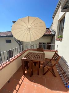 a wooden bench sitting on a balcony with an umbrella at The Perfect Base to Explore Tuscany - Between Pisa, Lucca, and Florence! - Netflix & YouTube Premium Included in Montecatini Terme