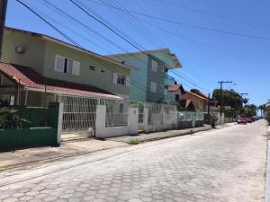 uma rua vazia com casas e uma cerca em Casa com 6 suítes e piscina, a 160m da praia em Florianópolis