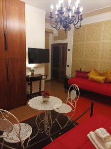 uma sala de estar com uma mesa e um sofá vermelho em B&B Centrum Palmi em Palmi