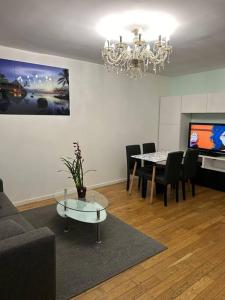 a living room with a table and a chandelier at Maison conviviale in Villejuif