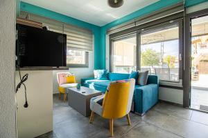 ein Wohnzimmer mit einem blauen Sofa und einem TV in der Unterkunft STREET 90 Luxury Apartment in Keramotí