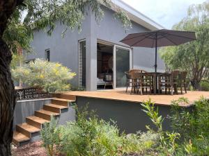 Casa con terraza con mesa y sombrilla en Injidup Beach Studio en Yallingup