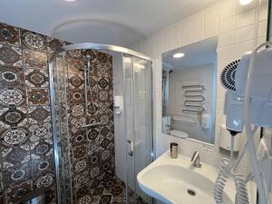 y baño con lavabo y ducha. en Stay Vilnius Hotel, en Vilna