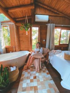 a woman sitting in a chair next to a bath tub at Itapeva Ecovillage in Torres