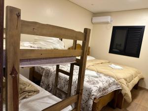 a bedroom with two bunk beds and a tv at HOTEL E RESTAURANTE NA CHÁCARA in Dourados