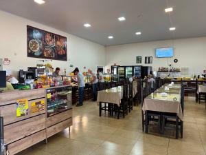 a restaurant with people preparing food at a counter at HOTEL E RESTAURANTE NA CHÁCARA in Dourados