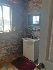 a bathroom with a white sink and a window at herencia de pioneros in Coihaique