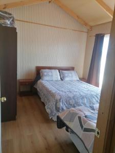 1 dormitorio con 1 cama y 1 mesa en herencia de pioneros, en Coyhaique