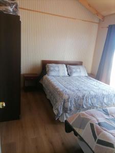 1 dormitorio con 1 cama con edredón azul en herencia de pioneros, en Coyhaique