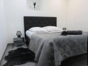 - une chambre avec un grand lit et une tête de lit noire dans l'établissement Le Bogolan ~ Cosy & Design, à Clermont-Ferrand