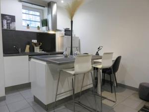 une cuisine avec un comptoir, des chaises et une table dans l'établissement Le Bogolan ~ Cosy & Design, à Clermont-Ferrand
