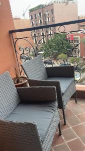 dwa wiklinowe krzesła siedzące na balkonie w obiekcie Appartement sur Marrakech w Marakeszu