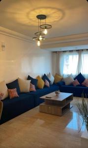 a living room with a blue couch and a coffee table at Appartement sur Marrakech in Marrakesh