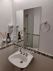 a bathroom with a sink and a large mirror at La Merced Apart in Córdoba