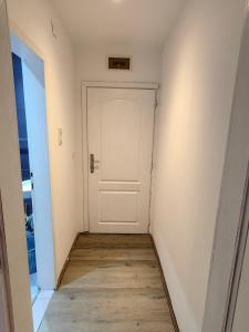 a hallway with a white door and a wooden floor at Apartmani MiS apartman br 2 in Soko Banja +37 photos