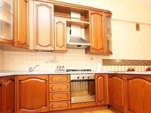 a kitchen with wooden cabinets and a stove top oven at ApartLux na Ploshadi Pobedy in Moscow