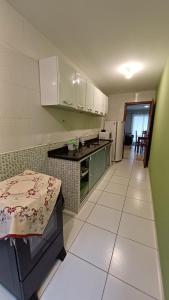 a kitchen with green cabinets and a white tile floor at Apart Angra dos Reis I in Angra dos Reis