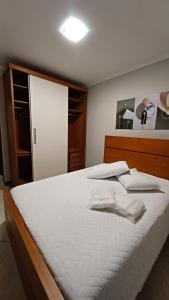 a bed with white sheets and pillows on it at Apart Angra dos Reis I in Angra dos Reis