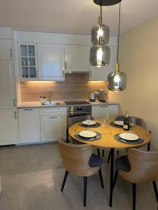 - une cuisine avec une table en bois, des chaises et un évier dans l'établissement Apartament Ski and Chill, à Karpacz