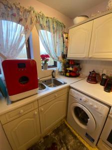 a kitchen with a sink and a washing machine at Cozy bedroom in well equipped apartment in Leatherhead
